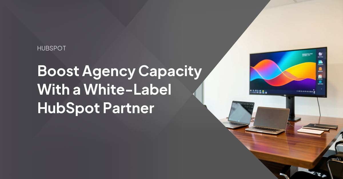 Two professionals reviewing a HubSpot portal dashboard together, representing a white-label partner extending an agency's delivery bench