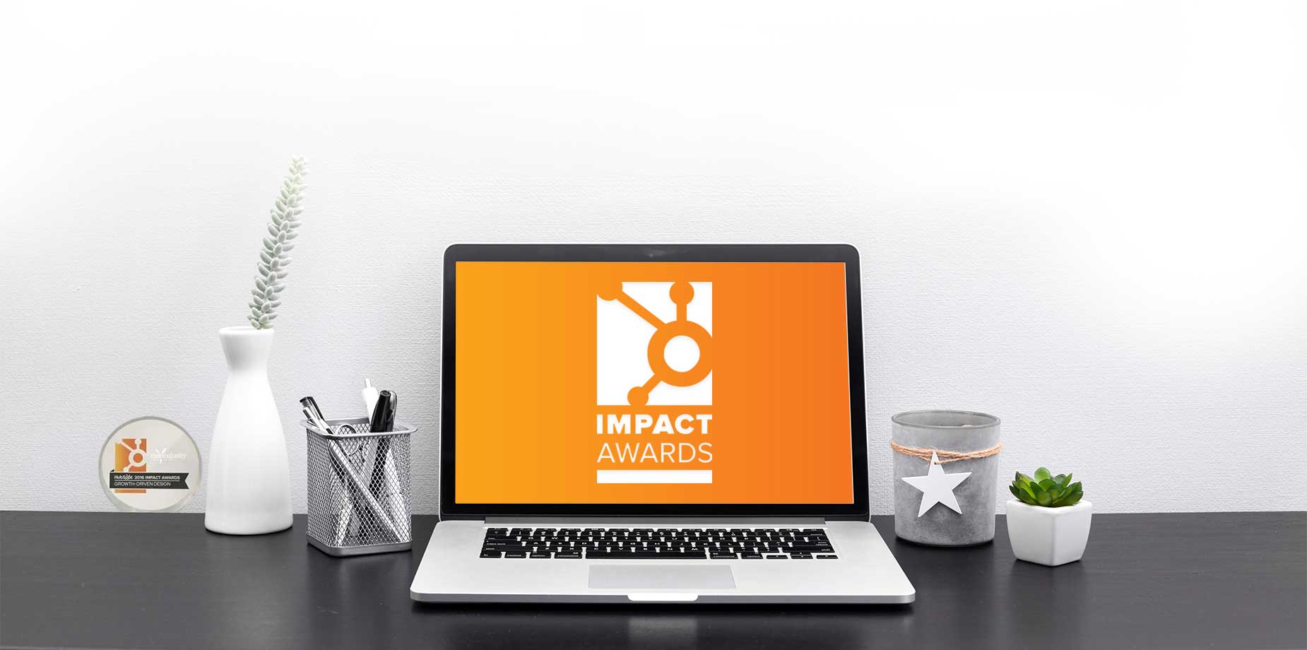 Laptop showing the HubSpot Impact Awards logo beside the 2016 Growth-Driven Design award