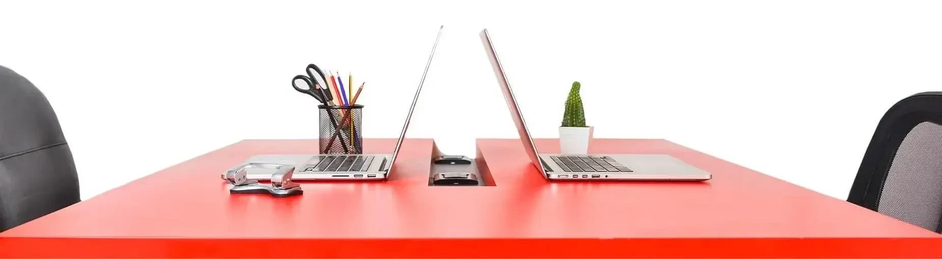 Two laptops facing each other on a red desk