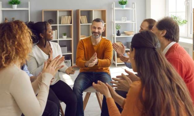 Six people group therapy session clapping
