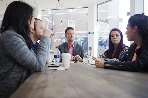 Small business team meeting over coffee to discuss how they project a clear, consistent image