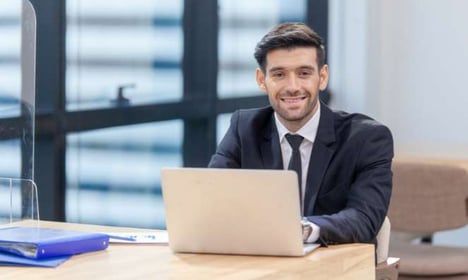 man smiling on the laptop while working